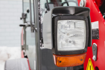 Headlight of tractor, red agricultural vehicle