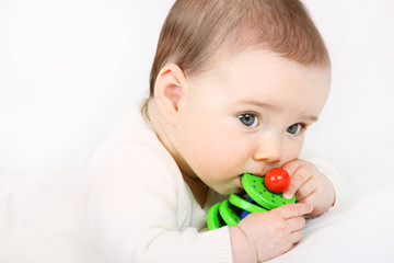 Ein Baby spielt mit einem Holzspielzeug 