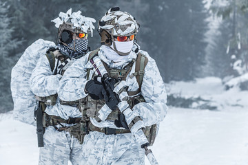 Winter arctic mountains warfare. Action in cold conditions. Troopers with weapons in forest...