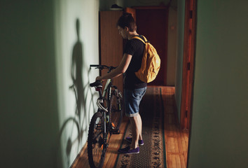 Obraz na płótnie Canvas young man taking his sport bicycle