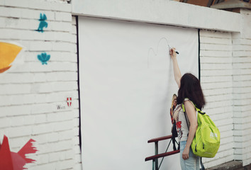 amazing girl drawing on the  white wall