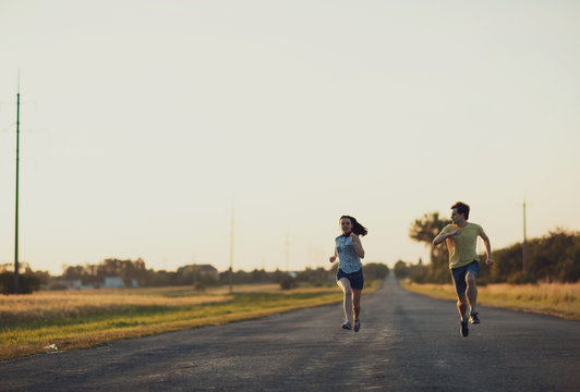 young sport  woman and her husband running on the broad road