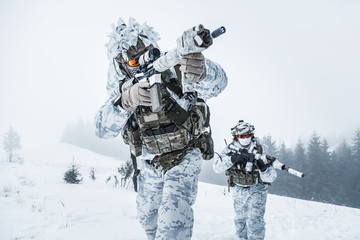 Winter arctic mountains warfare. Action in cold conditions. Pair of special forces weapons in forest somewhere above the Arctic Circle, low angle view
