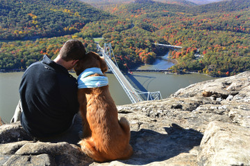 A young man and his twelve-year-old golden retriever taking a moment to admire the beautiful view...