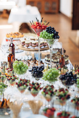 The vases with fruits stand on the buffet table