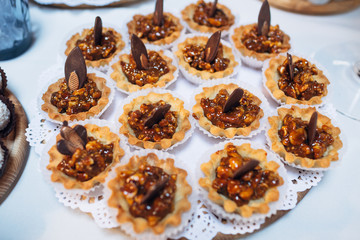 The small cakes with nuts stand on the banquet table