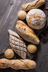 Several types of fresh bread lying on an old wooden table