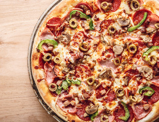 Italian pizza with cheese and olives macro. Pizza with mozzarella, olives and basil top view with copy space