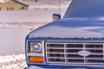 The Old Blue pickup truck covered with snow. Rural landscape. Winter in Wyoming, USA