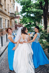 Obraz premium The bride with bridesmaids walking along street