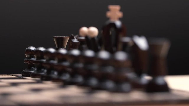 chess closeup, wooden chess board, business concept, black background. slide camera. Studio.