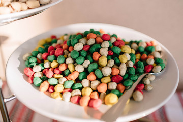 white plate with many green and white nuts in soft dough