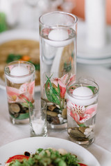 flowers and round candles floating in a glass of water