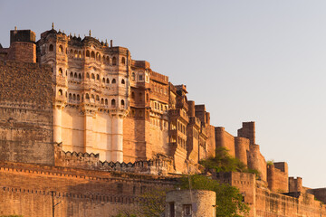 Details of Jodhpur fort at sunset. The majestic fort perched on top dominating the blue town. Scenic travel destination and famous tourist attraction in Rajasthan, India.