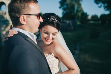 beautiful and young bride and groom hugging outdoors