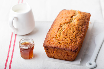 Cake, tea loaf with jam and cream on a textile white background.