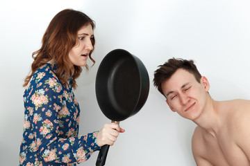 Woman with frying pan, naked man with a hangover