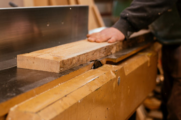 Hands of the craftsman cut a piece of wood