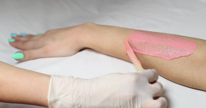 Process depilation female legs and hands in a beauty salon 