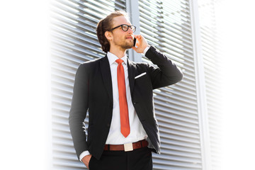 A businessman with a beard and glasses talking on the phone. Space for text.
