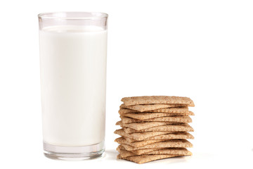 glass of milk with stack of grain crispbreads isolated on white background