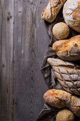 Several types of fresh bread lying on an old wooden table