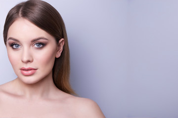 Fototapeta premium Fashionable portrait of a girl model. Natural makeup,nude shoulders, clean skin.Cosmetic concept .