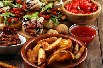 Italian antipasti wine snacks set. Cheese variety, Mediterranean olives, pickles, Prosciutto di Parma, tomatoes, artichokes and wine in glasses