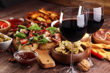 Fotobehang Italiaanse antipasti wijn snacks set. Kaassoort, Mediterrane olijven, augurken, Prosciutto di Parma, tomaten, artisjokken en wijn in glazen © beats_