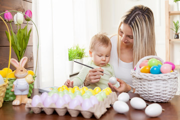 Obraz na płótnie Canvas Easter concept. Happy mother and her cute child getting ready for Easter