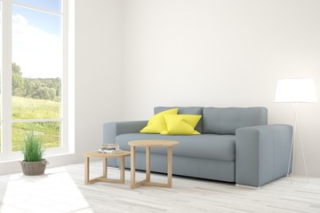 White room with sofa and green landscape in window. Scandinavian interior design
