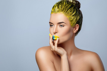 Beautiful woman with yellow hair and colorful nails and lips