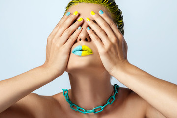 Beautiful woman with yellow hair and colorful nails and lips