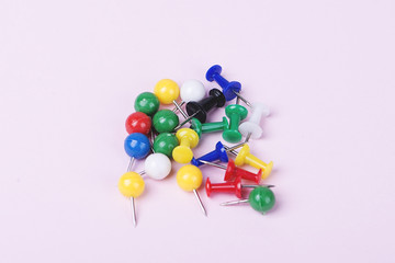 Colorful pushpin on pink background. Horizontal shoot.