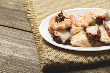 Tasty seafood salad on rustic table. Horizontal shoot.