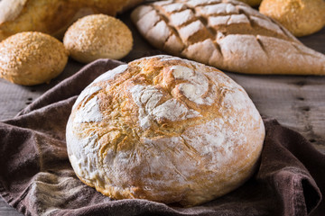 Several types of fresh bread lying on an old wooden table
