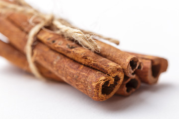 Macro or close up photo of cinnamon sticks bandaged by Twine on white background