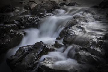 Rocks in stream with smooth flowing water.