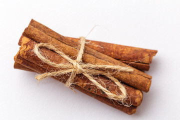 Macro or close up photo of cinnamon sticks bandaged by Twine on white background