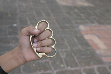 Hand man wearing brass knuckles