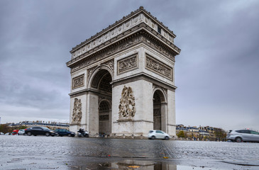 Fototapeta na wymiar Triumphal arch. Arc de triomphe. View of Place Charles de Gaulle. Famous touristic architecture landmark in rainy day. Long exposure photography. Paris. France.
