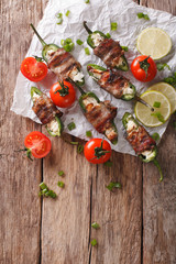 jalapeno peppers with feta cheese wrapped in bacon close-up. Vertical top view