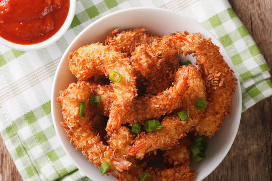 fried coconut shrimp closeup and tomato sauce. horizontal top view