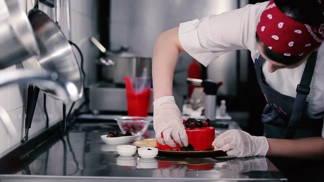 Woman decorate slices of chocolate cake bottom.
