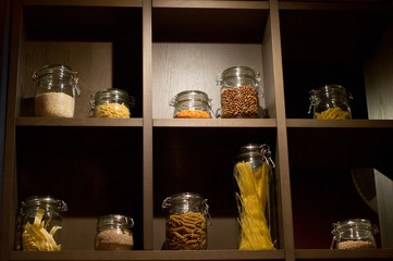 Shelf with jars containing pasta, rice, peas, and groats