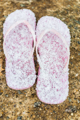 Pink flip flops covered in winter snow flakes