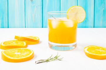 Glass of orange juice on wooden table, on wood plants background, fresh drink.