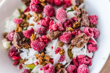 Dark pink raspberries in bowl with chocolate, chopped figs and fruit
