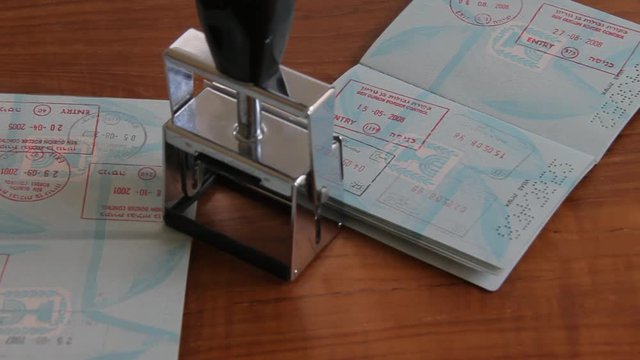 Passports and Stamp on Brown Wooden Desk.