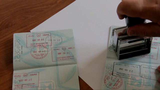 Police Officer Puting a Stamp Validated in the Passport